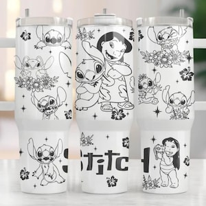 May include: White tumbler with a handle featuring black and white illustrations of Stitch and Lilo from the Disney movie Lilo & Stitch. The word "Stitch" is printed on the tumbler. The tumbler has a clear lid and a white handle.