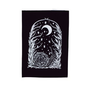 May include: A black card with a white illustration of a snail crawling under a crescent moon with stars in a night sky. The snail is surrounded by white leafy branches.