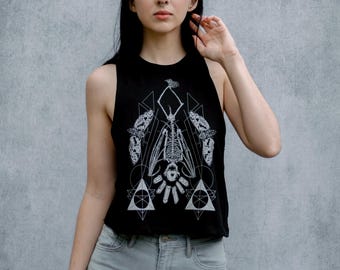 May include: A black tank top with a white graphic print of a skeletal bat with geometric shapes and butterfly wings.