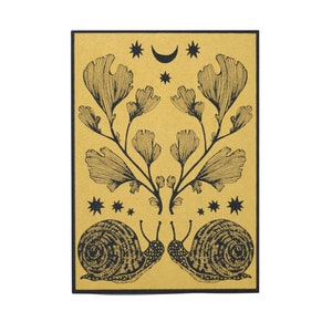 May include: A gold card with black ink illustration of two snails facing each other. The snails are surrounded by a symmetrical design of leaves and stars. A crescent moon and stars are at the top of the card.