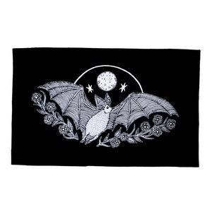 May include: A black and white illustration of a bat flying in front of a full moon with stars. The bat is surrounded by stylised flowers.