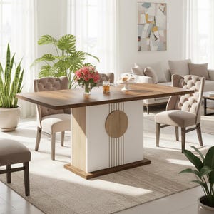 Puede incluir: Una mesa de comedor moderna con una tapa de madera oscura y una base blanca con un acento circular de madera. La mesa está rodeada de sillas tapizadas en un color neutro. Un jarrón de rosas rosas está sobre la mesa.