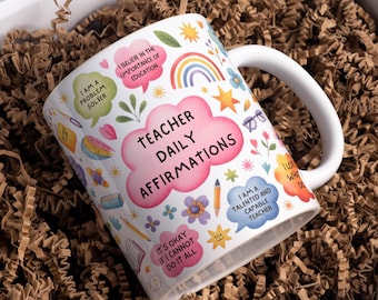 Pode incluir: Caneca de cerâmica branca com o texto "Teacher Daily Affirmations" em rosa. A caneca é decorada com ilustrações e afirmações coloridas, incluindo "I am a problem solver" e "I believe in the importance of education."