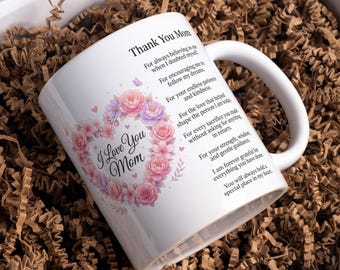 May include: White ceramic mug with a floral heart design and the text "I Love You Mom". The mug also features the text "Thank You Mom" and a heartfelt message. The mug is presented in a gift box with brown paper filler.