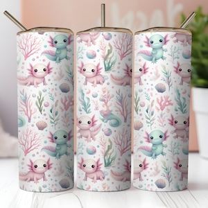 May include: Three stainless steel tumblers with a whimsical axolotl design. The pattern features pink and blue axolotls, coral, and seaweed on a white background. Each tumbler has a gold-colored rim and a straw.