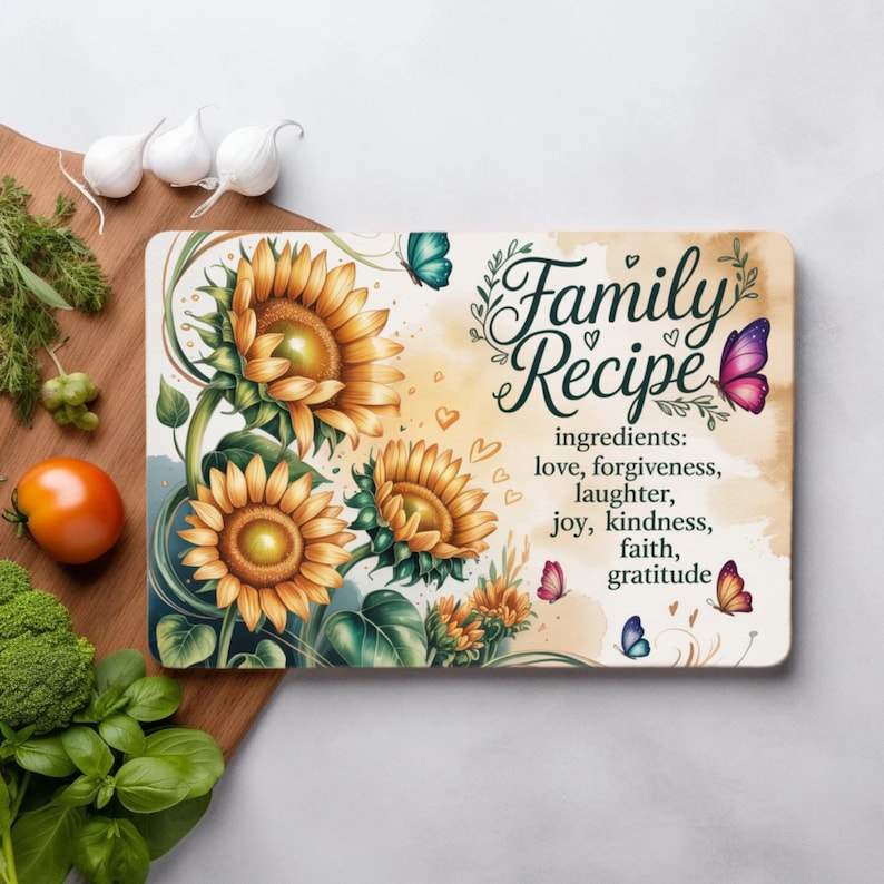 K&ouml;nnte beinhalten: Rechteckiges Schneidebrett mit Sonnenblumenmuster und dem Schriftzug "Family Recipe". Die aufgef&uuml;hrten Zutaten sind Liebe, Vergebung, Lachen, Freude, Freundlichkeit, Glaube und Dankbarkeit. Schmetterlinge und Herzen verzieren das Brett.