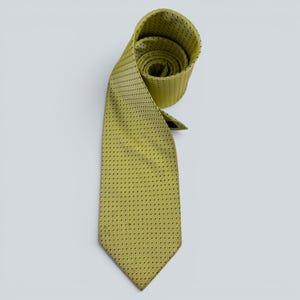 May include: A chartreuse necktie featuring a repeating pattern of small, dark, square-shaped geometric motifs. The tie is partially coiled at the top, displaying a textured fabric surface with a consistent grid-like design throughout the length.