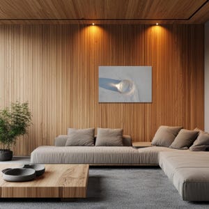 May include: A modern living room with a light brown sectional sofa, a wooden coffee table, and a wooden accent wall. A framed picture hangs on the wall. Potted plants are placed near a large window.