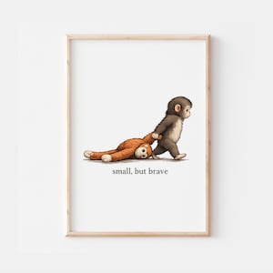 Op de afbeelding: Een ingelijste prent met een cartoon illustratie van een kleine aap die een groter knuffeldier trekt. De aap is bruin en wit, en het speelgoed is oranje. De tekst "small, but brave" staat onderaan de afbeelding.