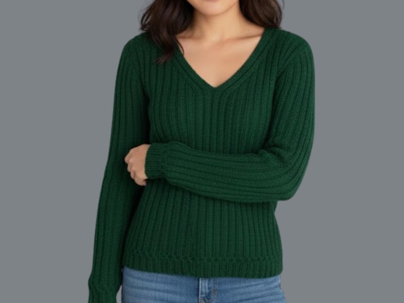 May include: A dark green, ribbed knit sweater with a V-neck. The long-sleeved top is made of a soft material and is paired with blue jeans. The sweater's texture and color create a classic, comfortable look.