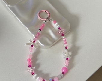 Correa para teléfono con cuentas rosas, detalles de corazón y flores