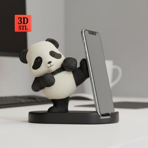 Könnte beinhalten: Ein schwarz-weißer Handyhalter in Form eines Pandas. Der Panda befindet sich in einer Karate-Haltung und hält ein Smartphone. Der Ständer ist schwarz und trägt den Text "3D STL" in einem roten Quadrat.