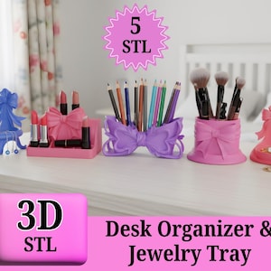 Puede incluir: Colección de organizadores de escritorio y bandejas para joyas rosas y moradas impresas en 3D. El conjunto incluye un soporte para lápiz labial, un portalápices, un soporte para brochas y una bandeja para joyas, todos con diseños en forma de lazo. También incluye el texto "3D STL" y "Desk Organizer & Jewelry Tray."