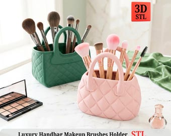 May include: A green and a pink handbag-shaped makeup brush holder, each filled with various makeup brushes. The holders have a quilted design and handles. The text "Luxury Handbag Makeup Brushes Holder STL" is at the bottom.