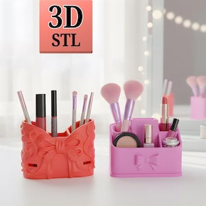 May include: Two decorative makeup organizers. One is coral-colored with a bow design, holding brushes and lip products. The other is pink, also with a bow, and contains makeup brushes, compacts, and nail polish. The image has the text "3D STL".