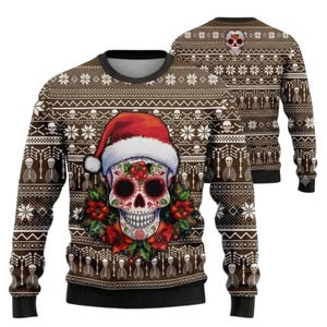 May include: A brown long-sleeve crewneck sweater featuring a repeating pattern of white skulls, bones, and snowflakes. The front displays a large sugar skull wearing a red and white Santa hat, surrounded by red poinsettia flowers and green leaves.
