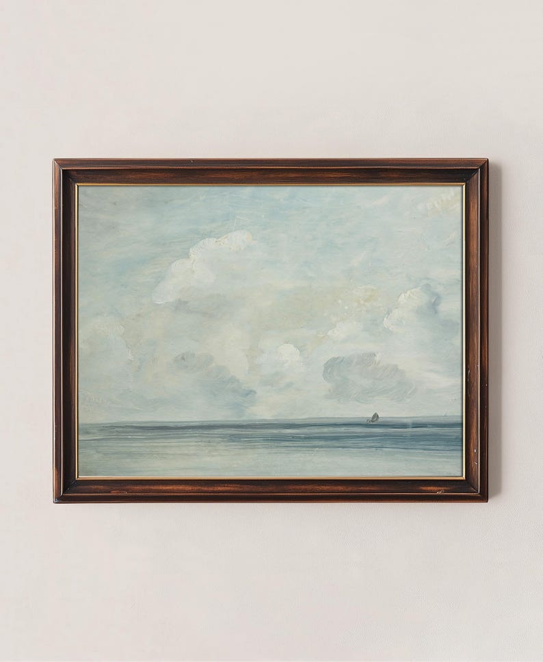 May include: A framed painting of a seascape with a light blue sky and white clouds. The sea is a dark blue and there is a small sailboat in the distance.