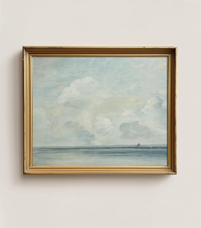 May include: A framed painting of a seascape with a light blue sky and white clouds. The sea is a dark blue and there is a small island in the distance.