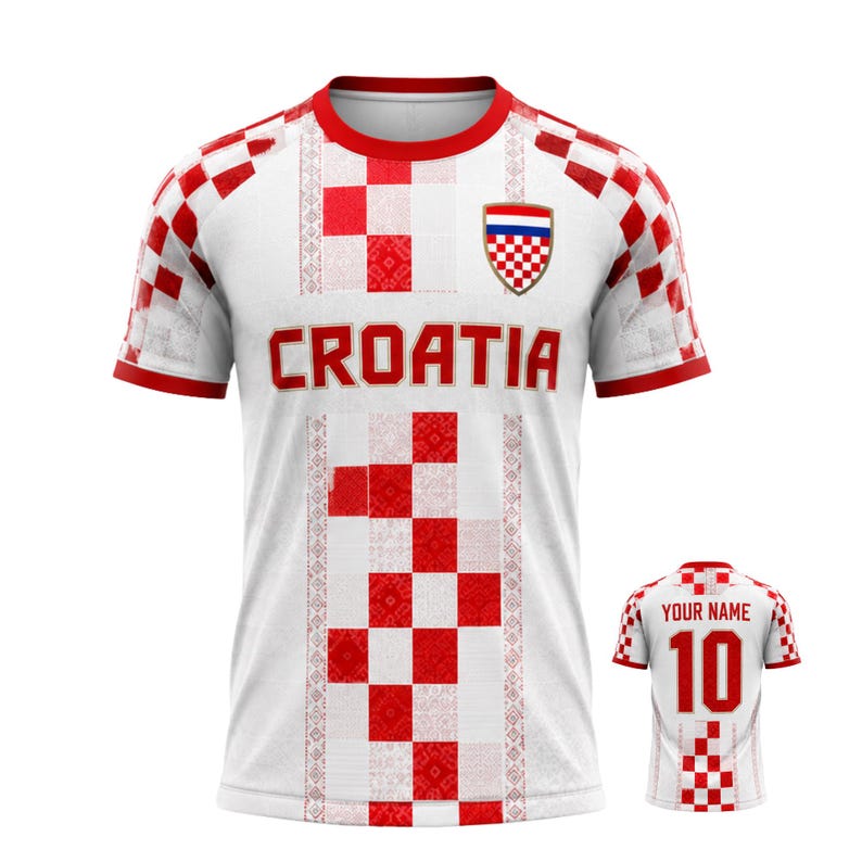 Pu&ograve; includere: Maglia da calcio bianca e rossa della Croazia con la scritta "CROATIA" sul petto. La maglia presenta un motivo a scacchi e lo stemma croato. &Egrave; visibile anche una maglia pi&ugrave; piccola con "YOUR NAME" e il numero 10.