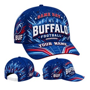 Puede incluir: Una gorra de béisbol azul con un gráfico de un horizonte urbano, el texto GAME DAY BUFFALO FOOTBALL y una sección personalizable YOUR NAME. El diseño incluye detalles en rojo y blanco, un icono de balón de fútbol y las siglas BUF.