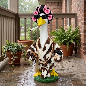 May include: A white goose figurine wearing a brown and white cow-print bathrobe, pink hair rollers, and black sunglasses. The goose holds a chocolate donut and a coffee cup, wears a gold chain, and has a cigarette in its yellow beak.