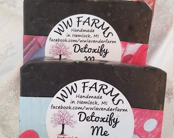 May include: Three bars of black charcoal soap stacked on top of each other. The soap is labeled "WW Farms" and "Detoxify Me". The soap is handmade in Hemlock, Michigan. The ingredients are listed as saponified olive and coconut oil, goat milk, activated charcoal, and pure essential oils.