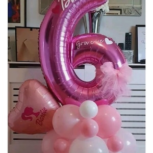 May include: A pink balloon display, featuring a large number 6 balloon with the names "Barbie" and "Gracie". The arrangement includes heart-shaped and round balloons in pink and white, suitable for a birthday party or celebration.