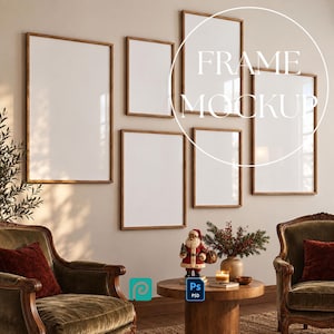 May include: A gallery wall arrangement featuring six empty rectangular picture frames with thin wooden borders. The frames are displayed on a light-colored wall above two upholstered armchairs and a round wooden table with a Santa figurine.