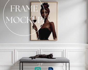 May include: A rectangular wooden frame containing an illustration of a person with a dark complexion wearing a black top and a headwrap, holding a wine glass. The text FRAME MOCKUP is overlaid in white. A black cat rests on a gray bench below the frame.