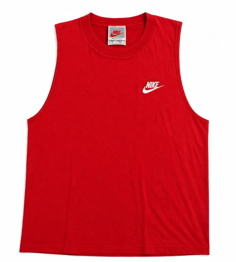 May include: A sleeveless red tank top with a crew neck. The Nike logo is printed in white on the upper left chest. A small Nike tag is visible near the neckline.