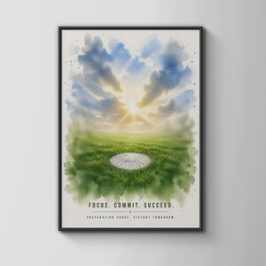 May include: A framed wall art print featuring a watercolour landscape of a green field under a bright sunlit sky with clouds. A white circular patch sits in the centre of the grass. The text reads: FOCUS. COMMIT. SUCCEED. PREPARATION TODAY. VICTORY TOMORROW.