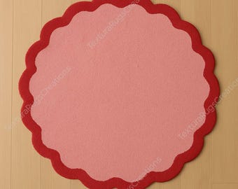 May include: A round rug with a scalloped edge. The rug has a light pink center and a dark red border. The rug is placed on a light brown wooden floor.