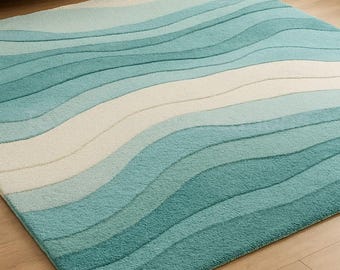 Puede incluir: Una alfombra rectangular con un patrón de ondas en tonos azules y blancos. El diseño presenta bandas horizontales de diferentes anchos, creando una estética texturizada inspirada en el océano. La alfombra está hecha de un material suave.