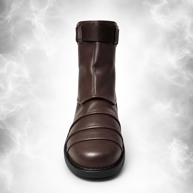 May include: A dark brown mid-calf boot featuring a smooth, rounded toe and a series of horizontal, layered panels across the vamp. The upper shaft includes a matching brown fabric strap with a buckle closure at the top, set on a black sole.