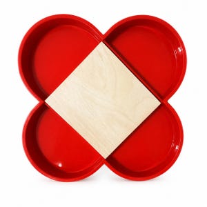May include: A bright red, four-sectioned clover-shaped serving tray featuring a central square light-colored wooden insert. The tray has smooth, rounded edges and a glossy finish, providing four distinct compartments for organizing various items.