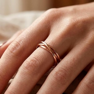 Minimalistischer Stapelring mit gekreuzten Bändern und ineinandergreifenden Ringen in Gold, Silber oder Roségold