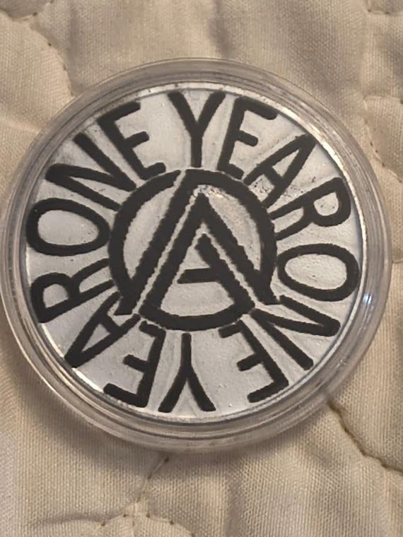 1 year sobriety coin made from a feau gold coin engraved.  I can paint them any color. I ship for exactly what it costs me.