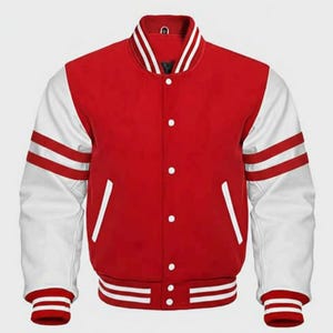 Puede incluir: Chaqueta universitaria roja con mangas blancas y rayas blancas. La chaqueta tiene una parte delantera abotonada, cuello, puños y dobladillo acanalados. Una prenda de abrigo clásica de inspiración atlética.