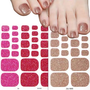 Puede incluir: Pegatinas de uñas con purpurina en tonos rosa, rojo y dorado. La imagen muestra un pie con esmalte de uñas dorado con purpurina y varias hojas de pegatinas adhesivas para uñas de varios tamaños y colores. Las pegatinas están diseñadas para las uñas de los pies.