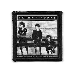 Puede incluir: Parche en blanco y negro con la banda Skinny Puppy. La imagen muestra tres figuras con ropa oscura y pelo puntiagudo. El nombre de la banda está impreso en letras blancas en la parte superior del parche.