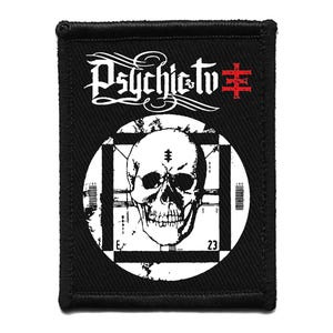 May include: Black rectangular patch featuring the text "Psychic TV" in white script above a white circle with a skull graphic. The circle is set against a black and white checkered background. A red symbol is on the right.