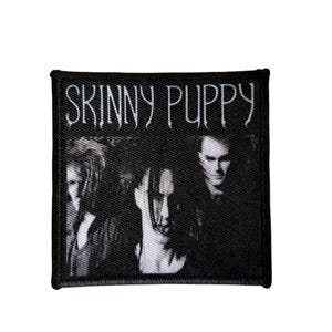 Puede incluir: Parche en blanco y negro con el nombre de la banda "SKINNY PUPPY" en letras blancas. El parche tiene un borde negro y una imagen en escala de grises de tres miembros de la banda.