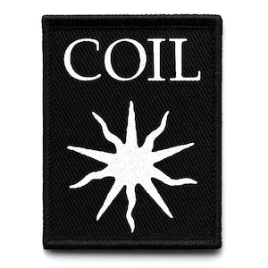 May include: Black rectangular patch with the word "COIL" in white capital letters above a white, stylized sunburst design. The patch has a black border and is likely made of fabric.