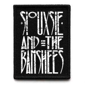 Pode incluir: Patch bordado preto com o texto "Siouxsie and the Banshees" em letras brancas desgastadas. O patch tem uma borda preta e formato retangular.