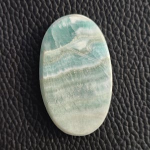 May include: A handmade, wooden cutting board with a natural finish. The board features a live edge on one side and a smooth, rectangular shape. It is approximately 18 inches long and 12 inches wide.