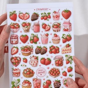Pu&ograve; includere: Un foglio di adesivi bianco intitolato STRAWBERRY TREATS con varie illustrazioni di fragole, inclusi frutti interi e affettati, bacche ricoperte di cioccolato, latte alla fragola, marmellata, cupcake, torte e cestini pieni di fragole fresche.