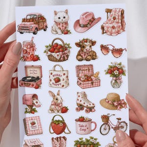 Pu&ograve; includere: Un foglio di adesivi con illustrazioni a tema fragola. I disegni includono un camion rosa, un gattino, un cappello da cowboy, un cestino di fragole, una mucca, occhiali da sole e pattini a rotelle. Il foglio misura 11,68 cm x 16,76 cm.