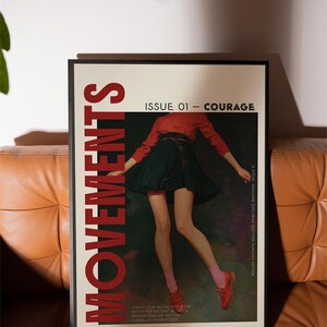 May include: A framed poster with the word "MOVEMENTS" in large red letters. The poster features a person in a red top and dark skirt, with the text "ISSUE 01 - COURAGE". The poster is on a brown leather couch.