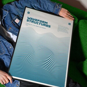 May include: A framed poster with the title "WAVEFORM STRUCTURES" and the subtitle "A Study on Line, Space and Motion". The poster features a teal and white wavy line design. The poster is held by a person wearing a denim jacket.