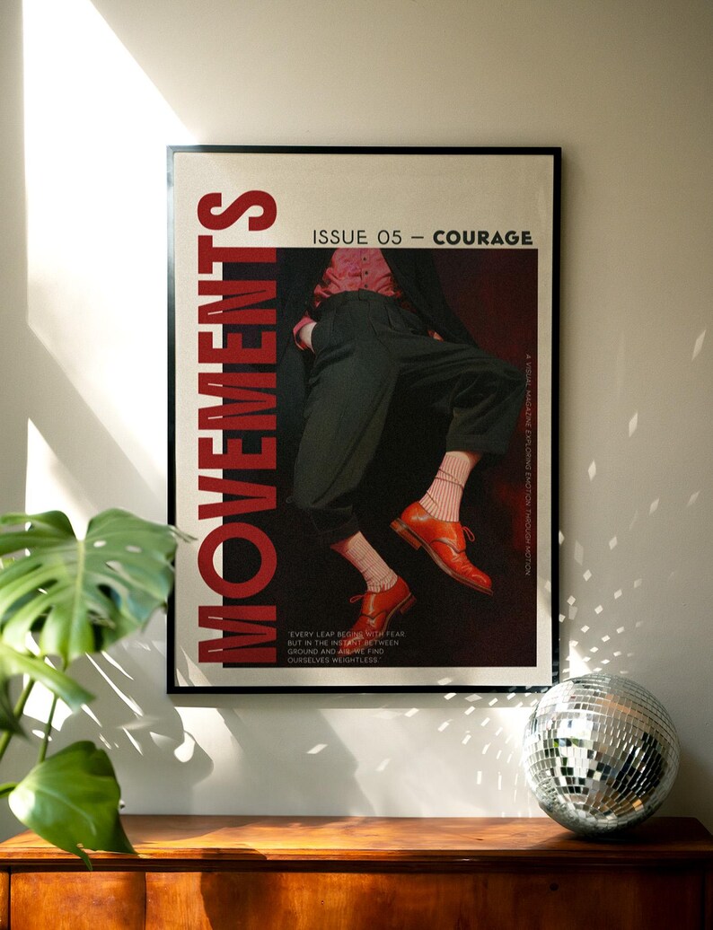 May include: A framed poster with the word "MOVEMENTS" in large red letters. The poster features a person in a pink shirt, black pants, and orange shoes. Text on the poster reads "ISSUE 05 - COURAGE" and a quote about fear and weightlessness.